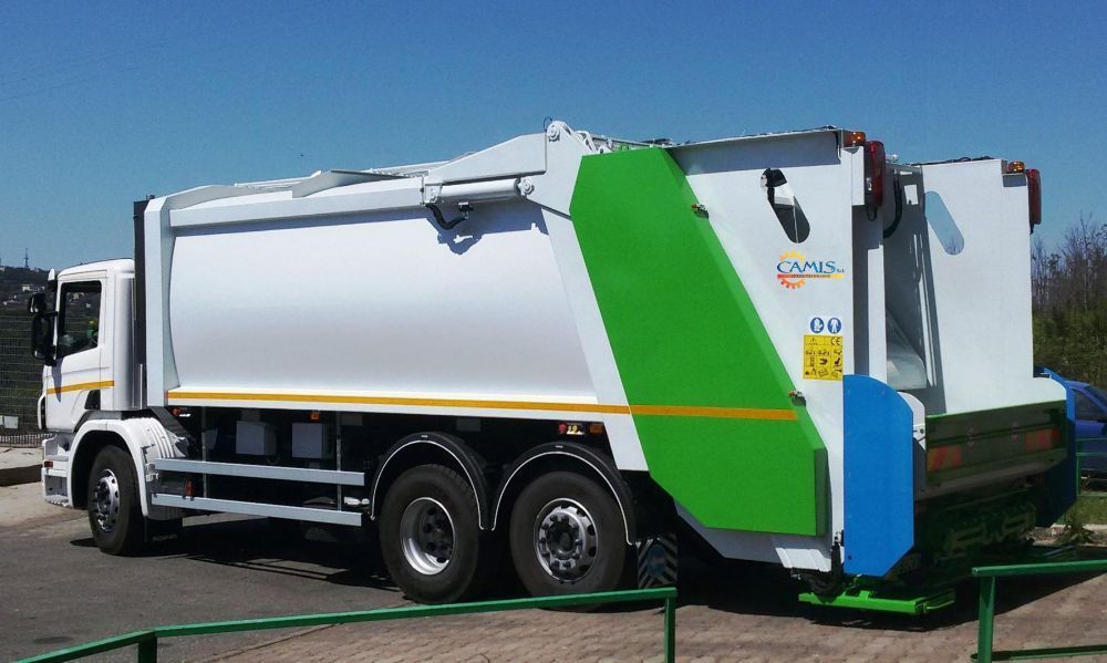 Camion della spazzatura bianco con attrezzatura posteriore verde e blu su strada, vista laterale