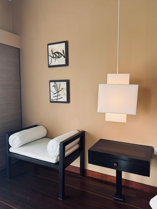 A room with a bench and a lamp hanging from the ceiling