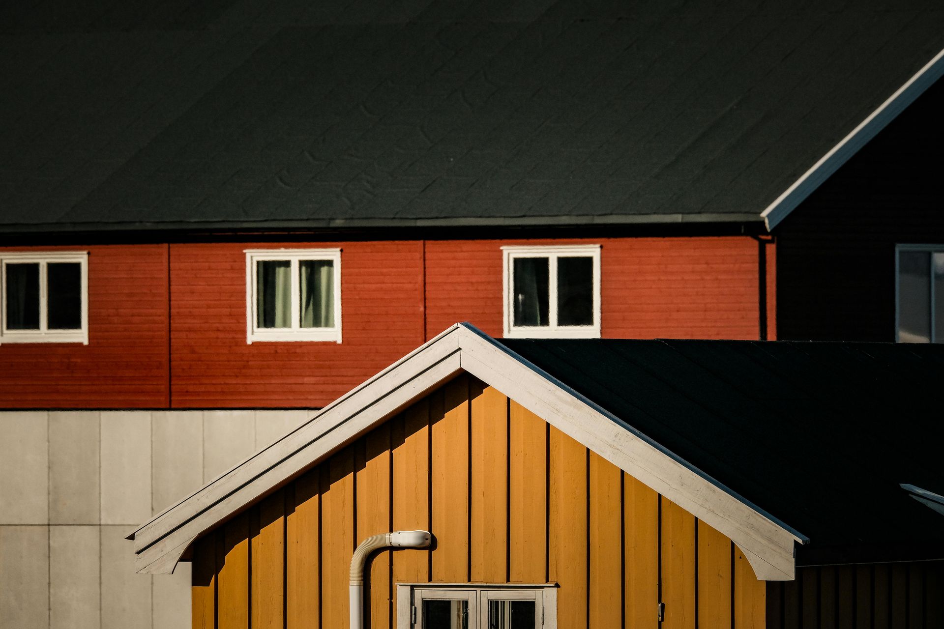 A red and yellow house with a black roof.