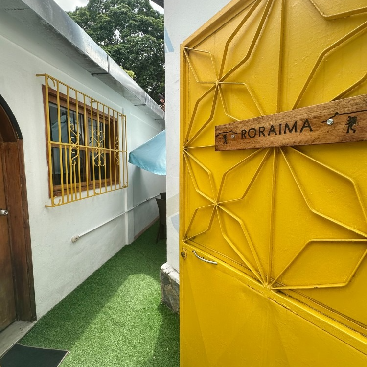 Yellow gate with star-like cutouts and a wooden sign