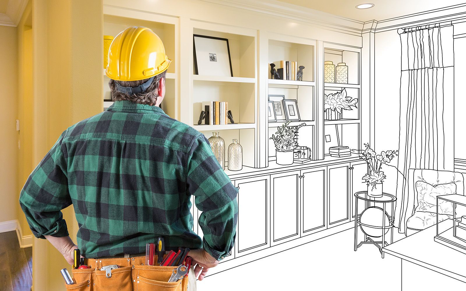 A man wearing a hard hat is standing in front of a drawing of a room.