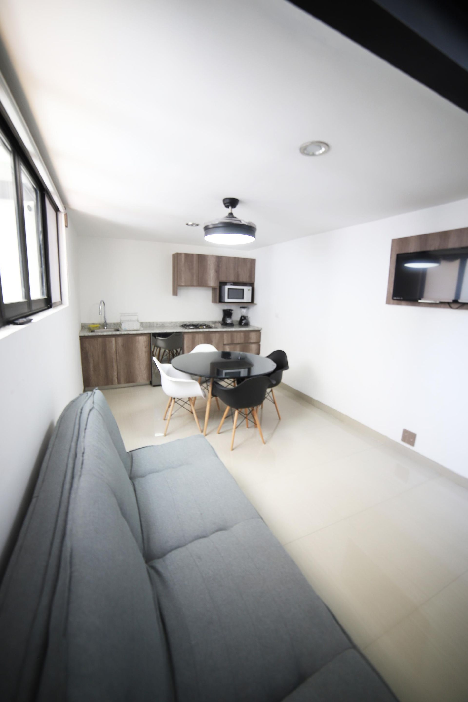 Una sala de estar con un sofá, una mesa y sillas.