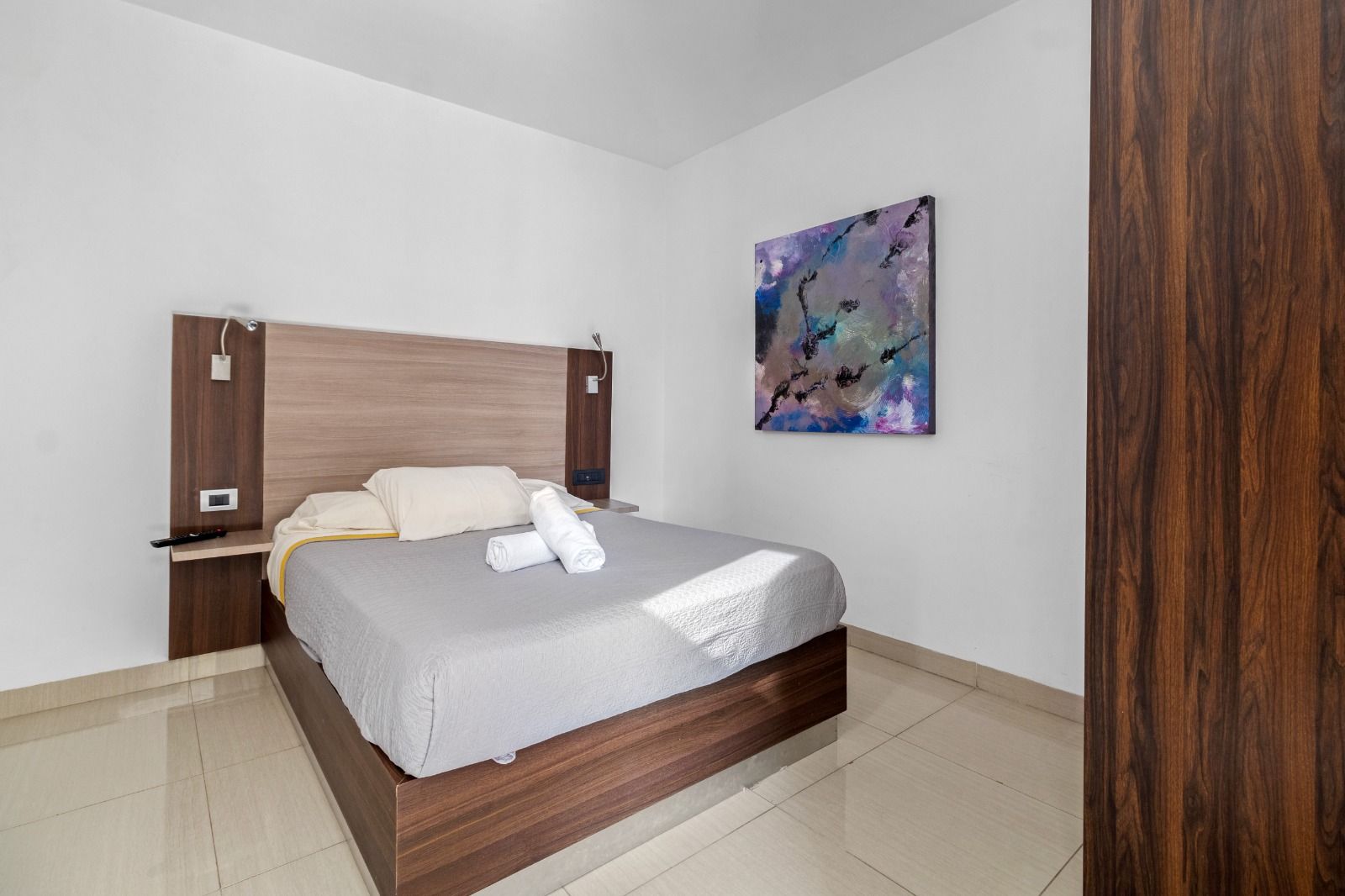 Un dormitorio con una cama grande y un cuadro en la pared.