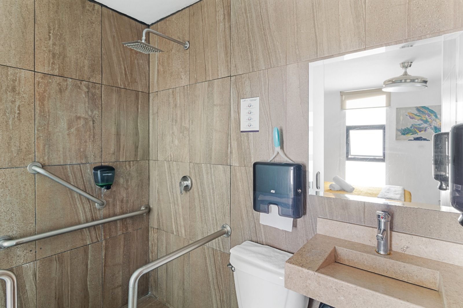Un baño con inodoro, lavabo, ducha y espejo.
