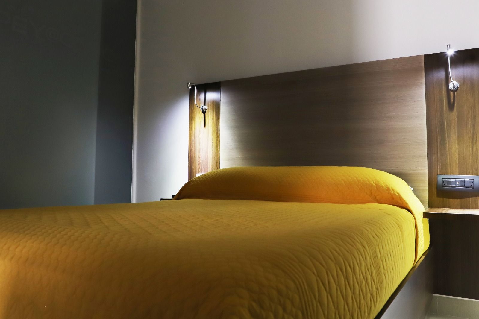 Una cama con un edredón amarillo en una habitación de hotel.