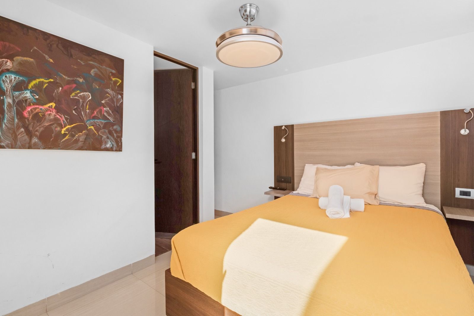 Un dormitorio con una cama grande y un ventilador de techo.