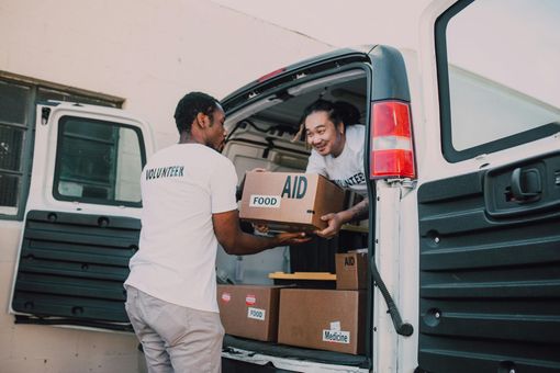 Two people loading boxes labeled 