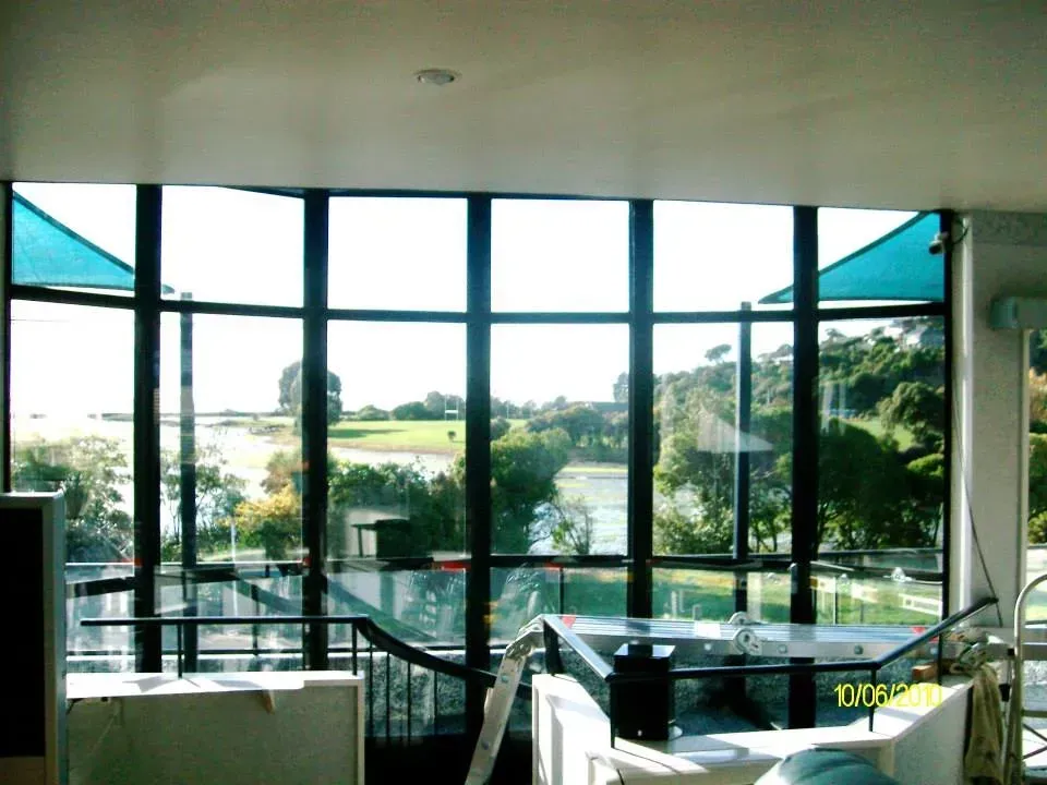 A living room with lots of windows and a blue umbrella