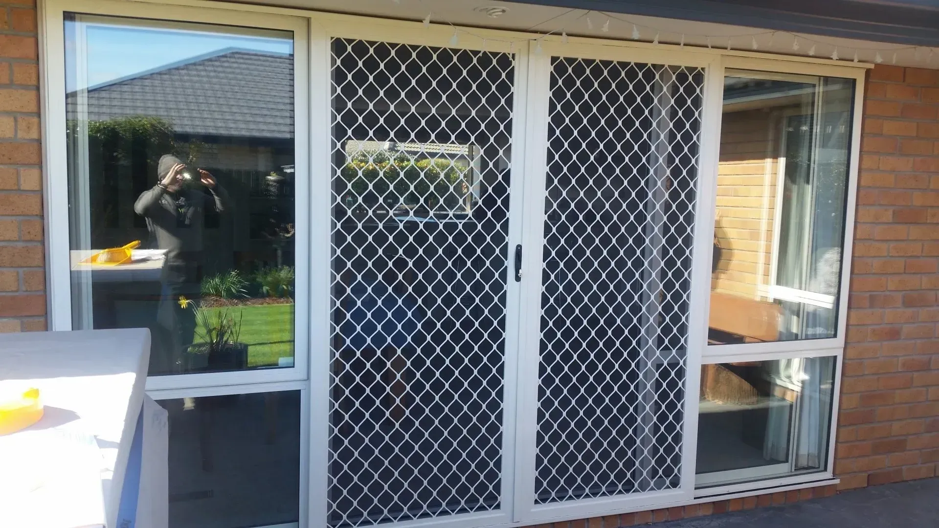 A person is taking a picture of a sliding glass door.