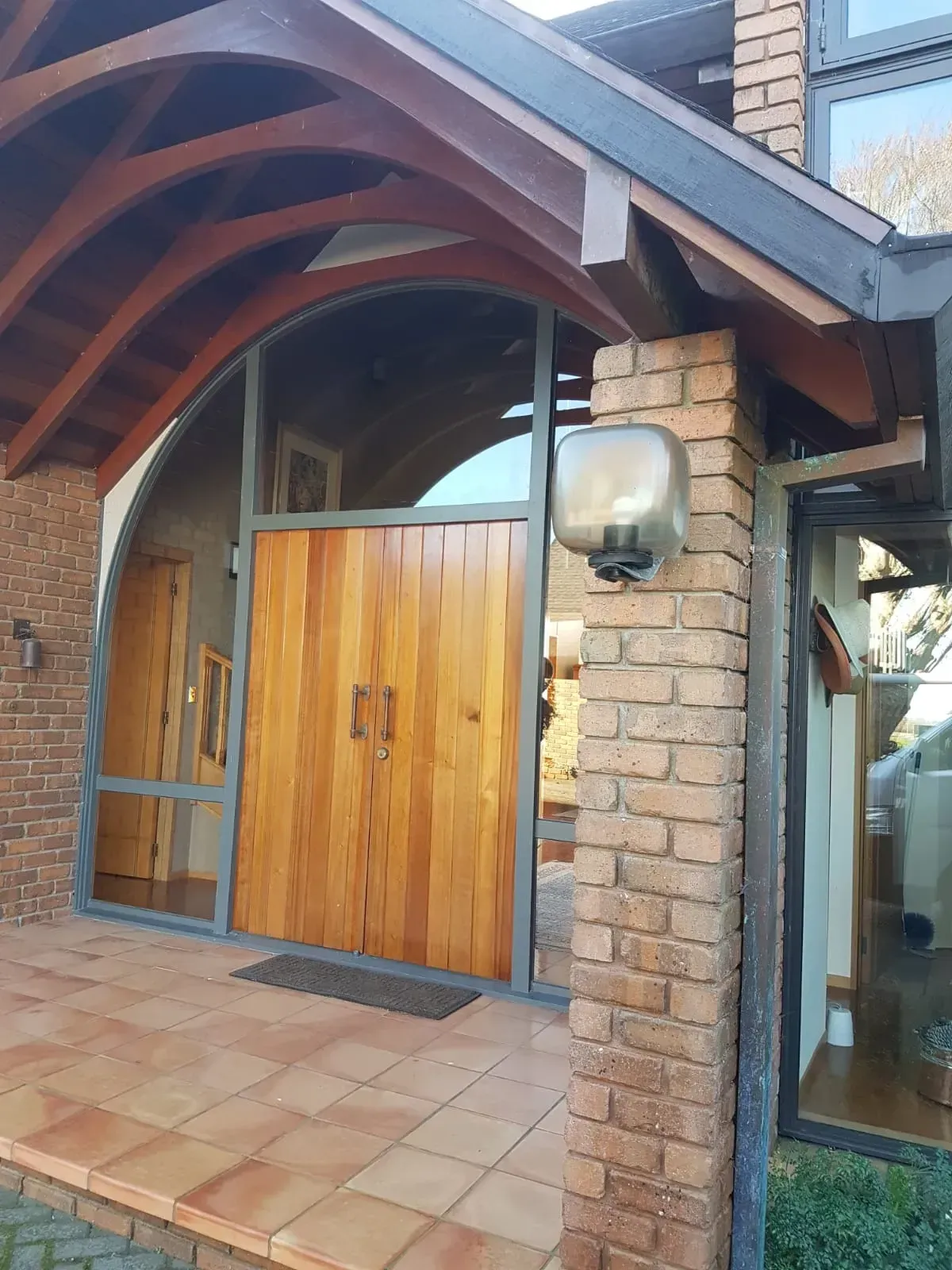 A house with a wooden door and a brick pillar