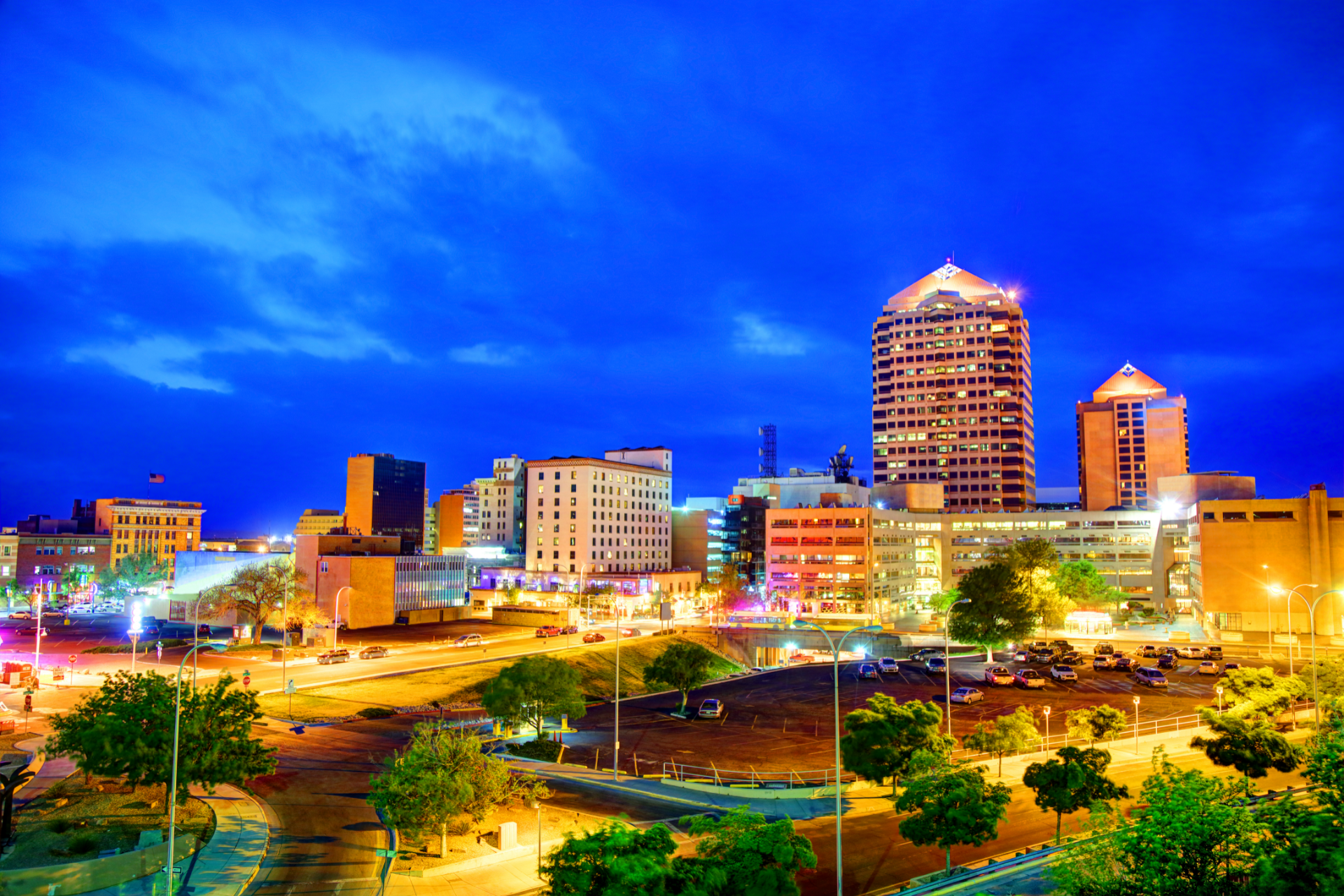 An aerial view of a city at night with lots of buildings and trees.