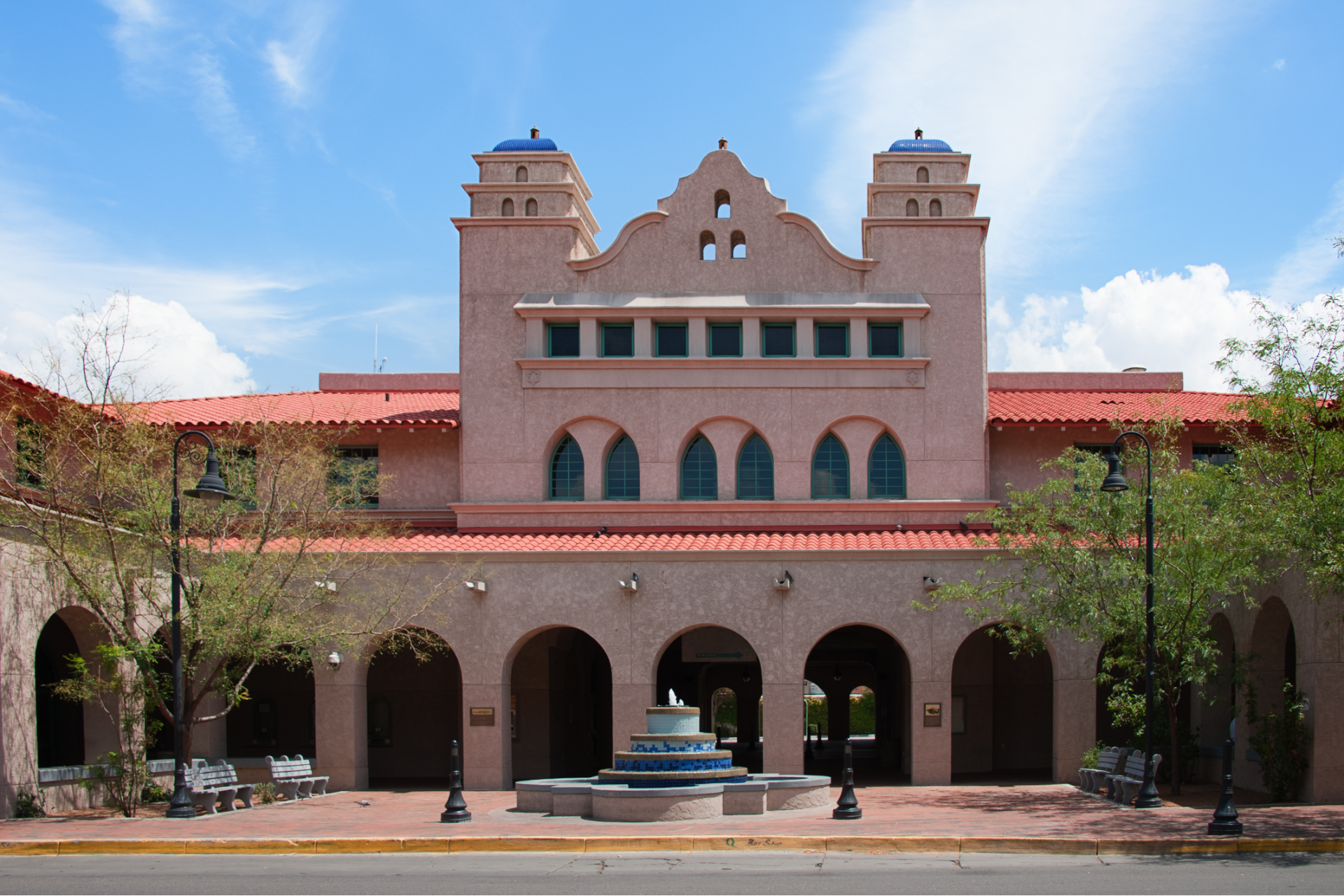 A large building with arches and a fountain in front of it