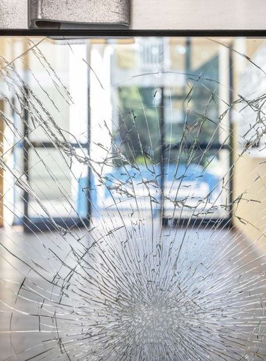 A close up of a broken glass door in a building.