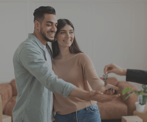A man is giving a woman the keys to their new home.