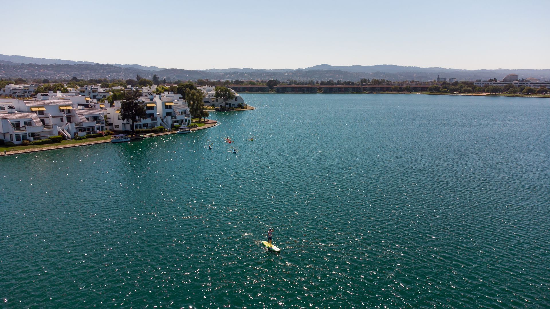 An aerial view of a large body of water with houses in the background.