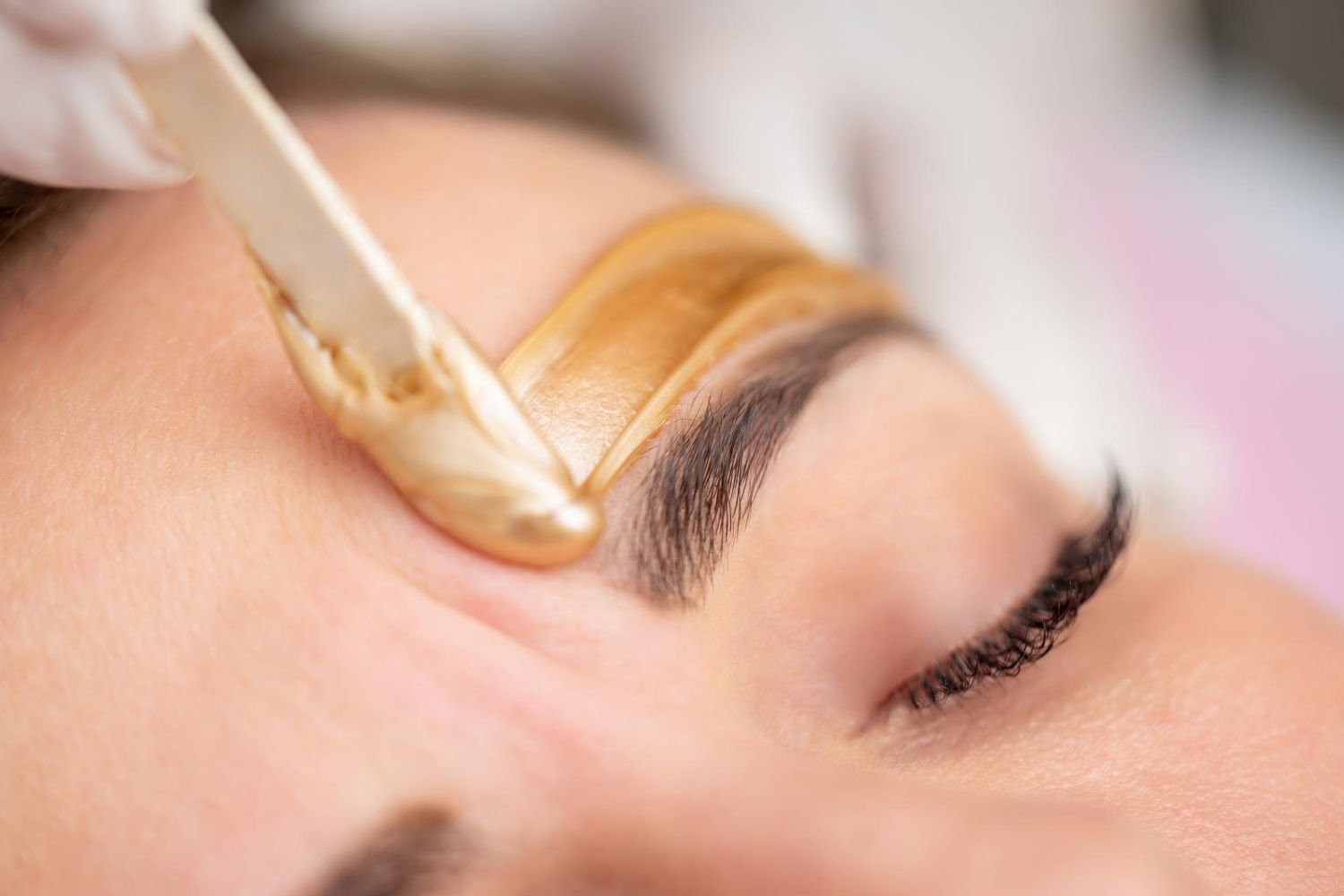 Wax being applied to an eyebrow during a beauty treatment
