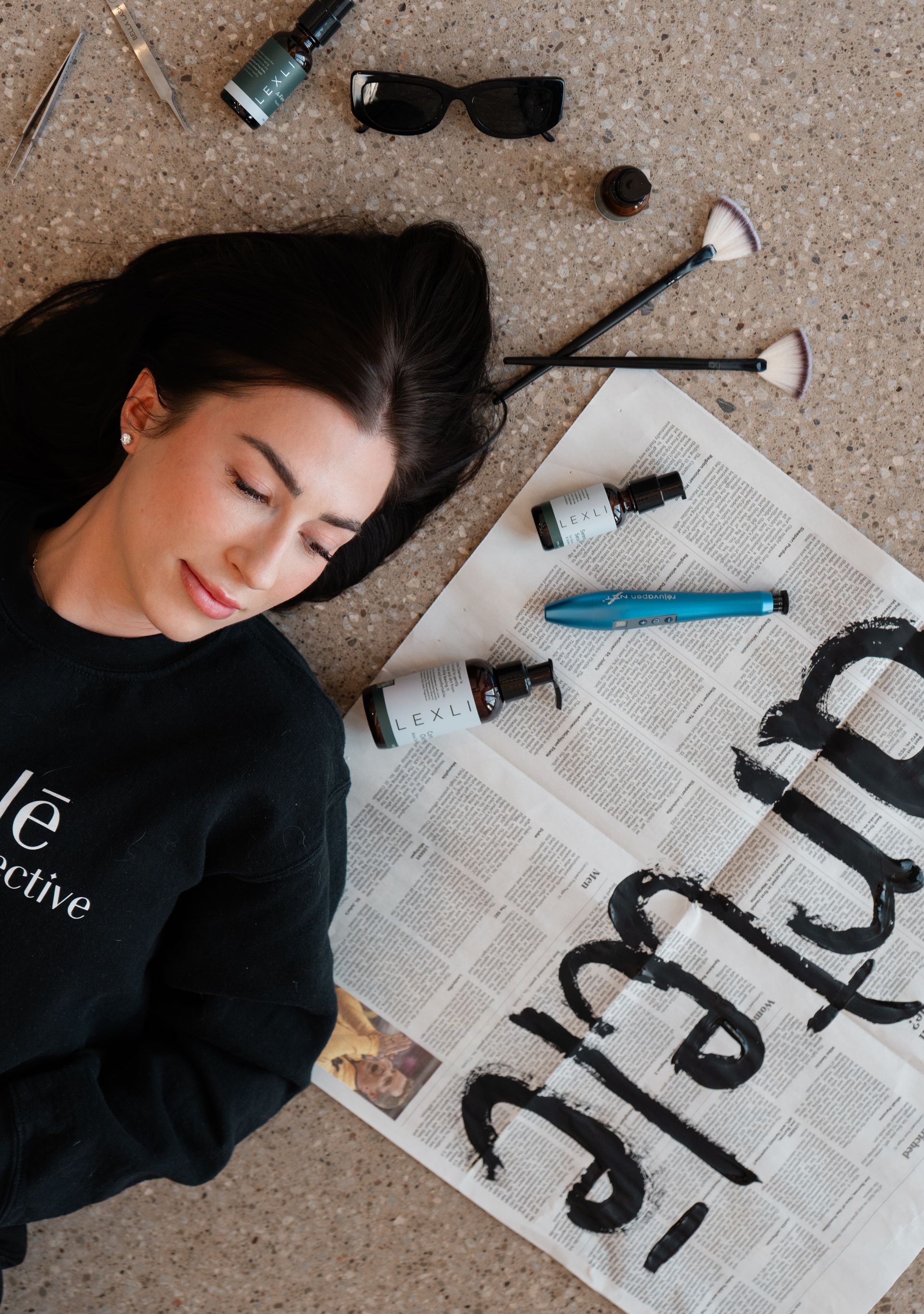 A woman is touching her face with her hand and looking at the camera.
