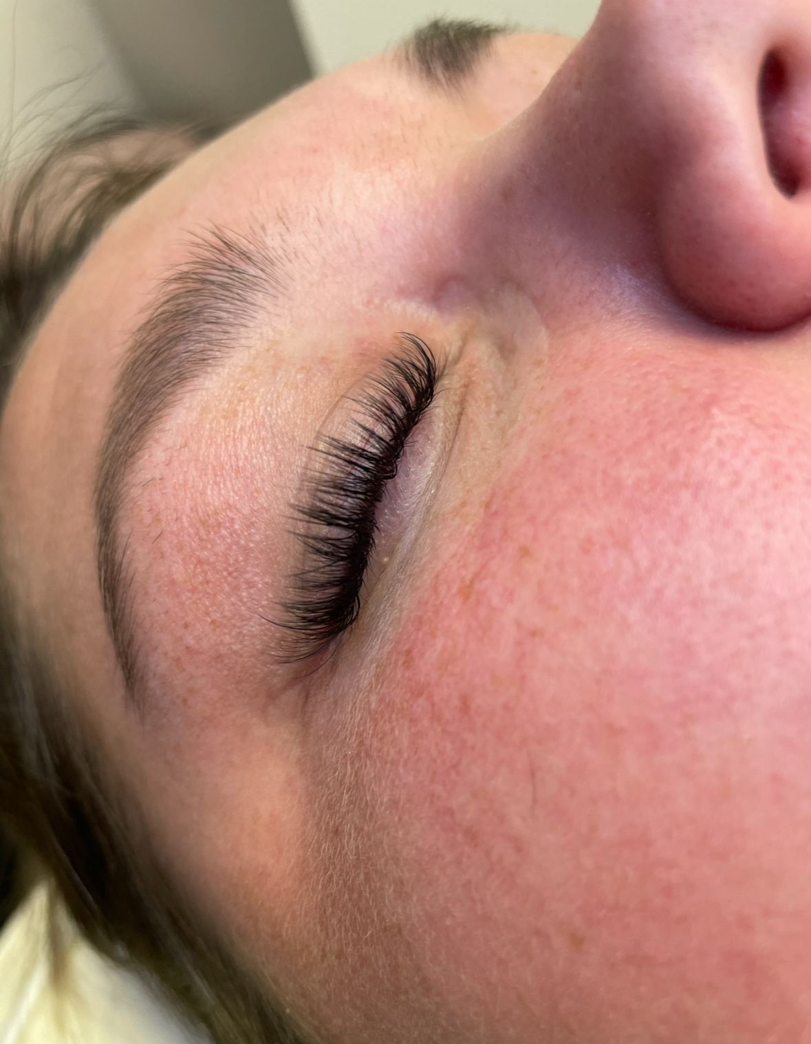A close up of a woman 's face with her hand on her chin.