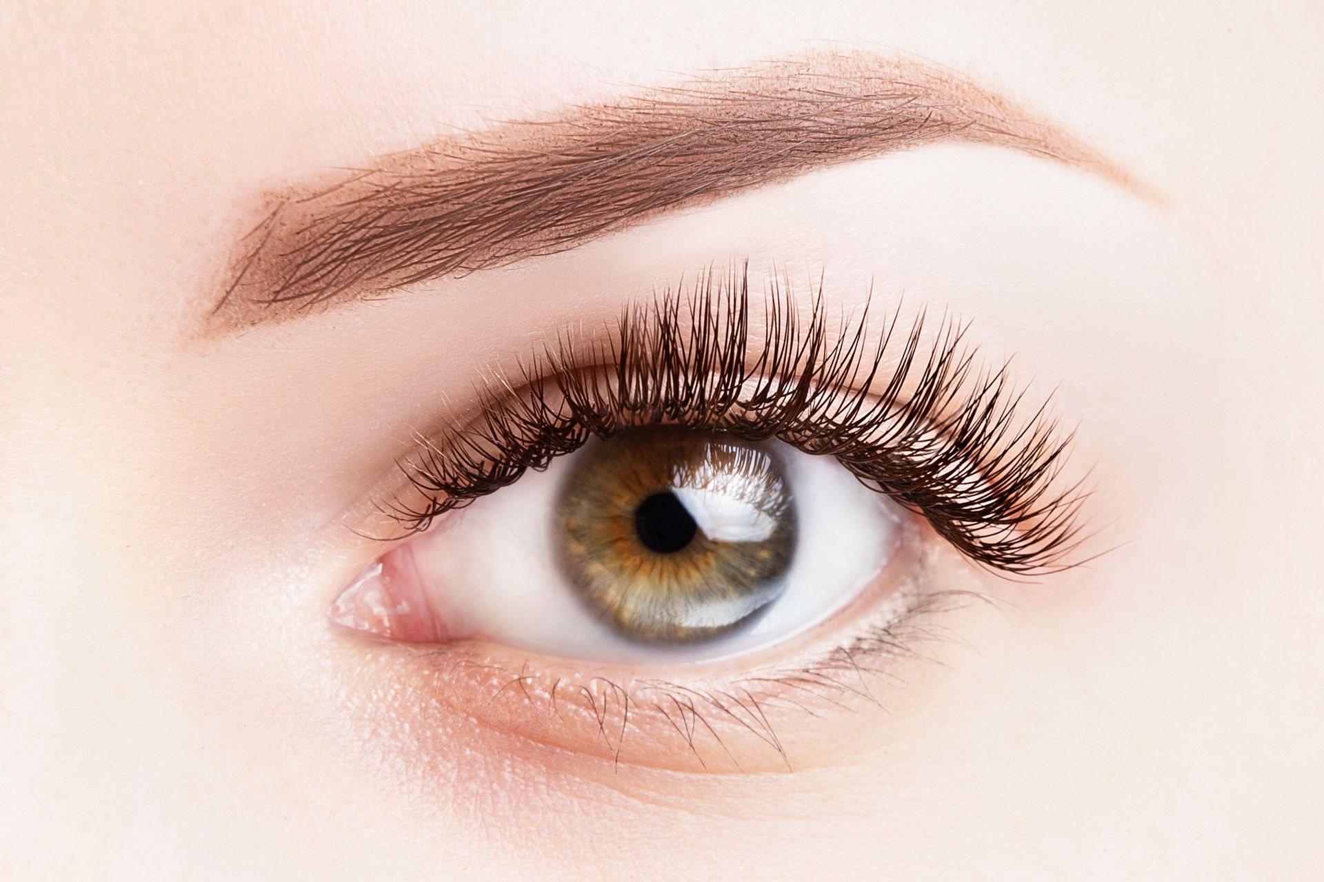 A close up of a woman 's eye with long eyelashes.