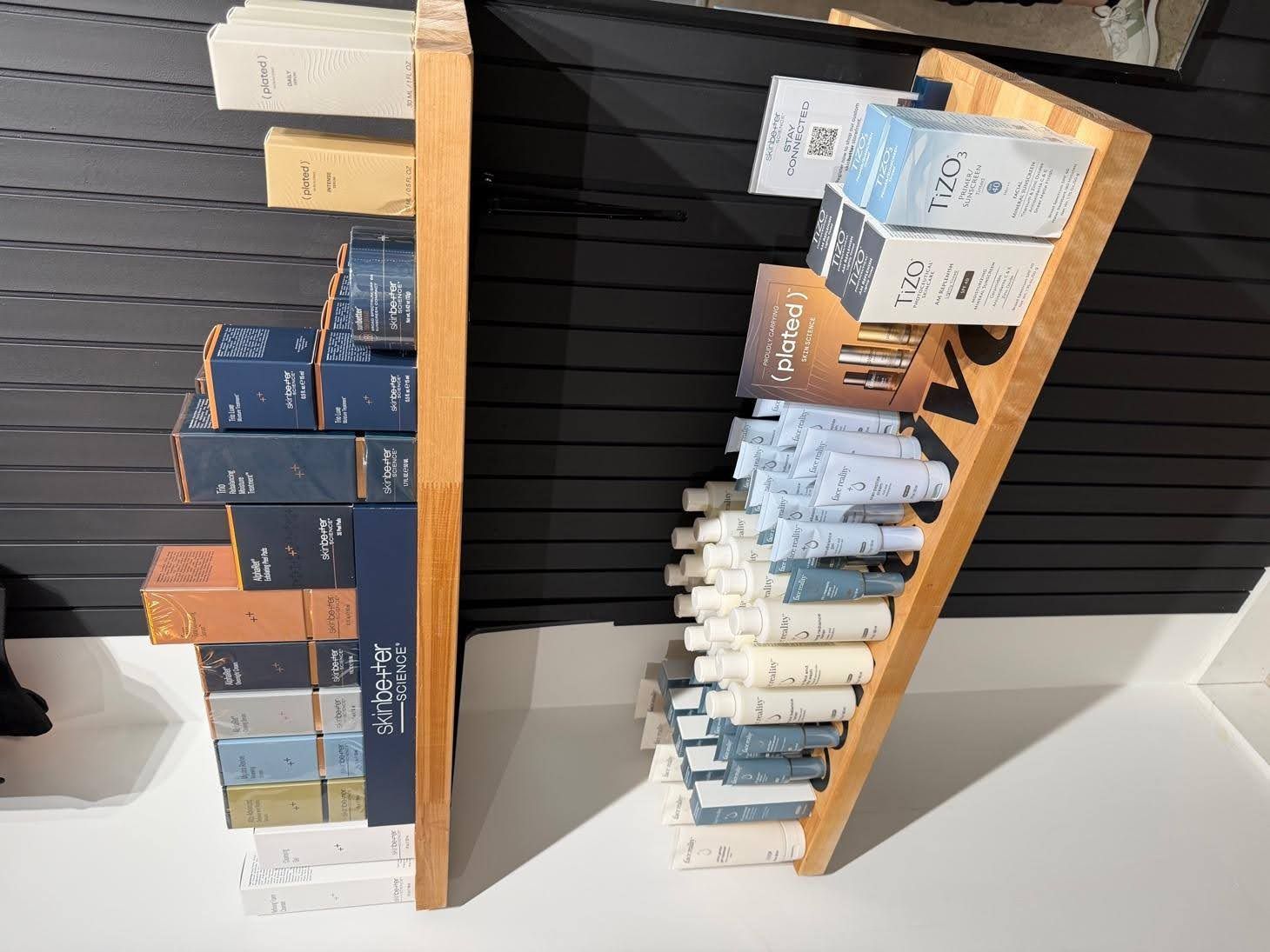 Two wooden retail displays holding stacked and organized product boxes.