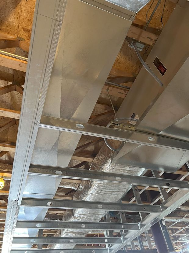 A large metal pipe is hanging from the ceiling of a building.