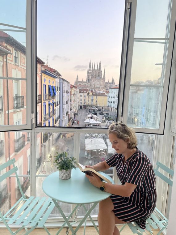 Marit zit aan een tafel en leest een boek.