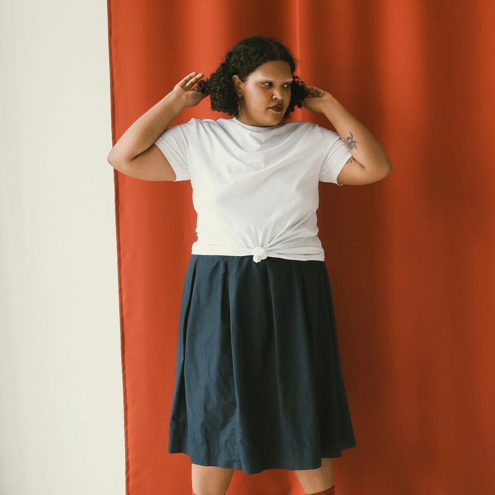 A person wearing a leopard print dress and a necklace.
