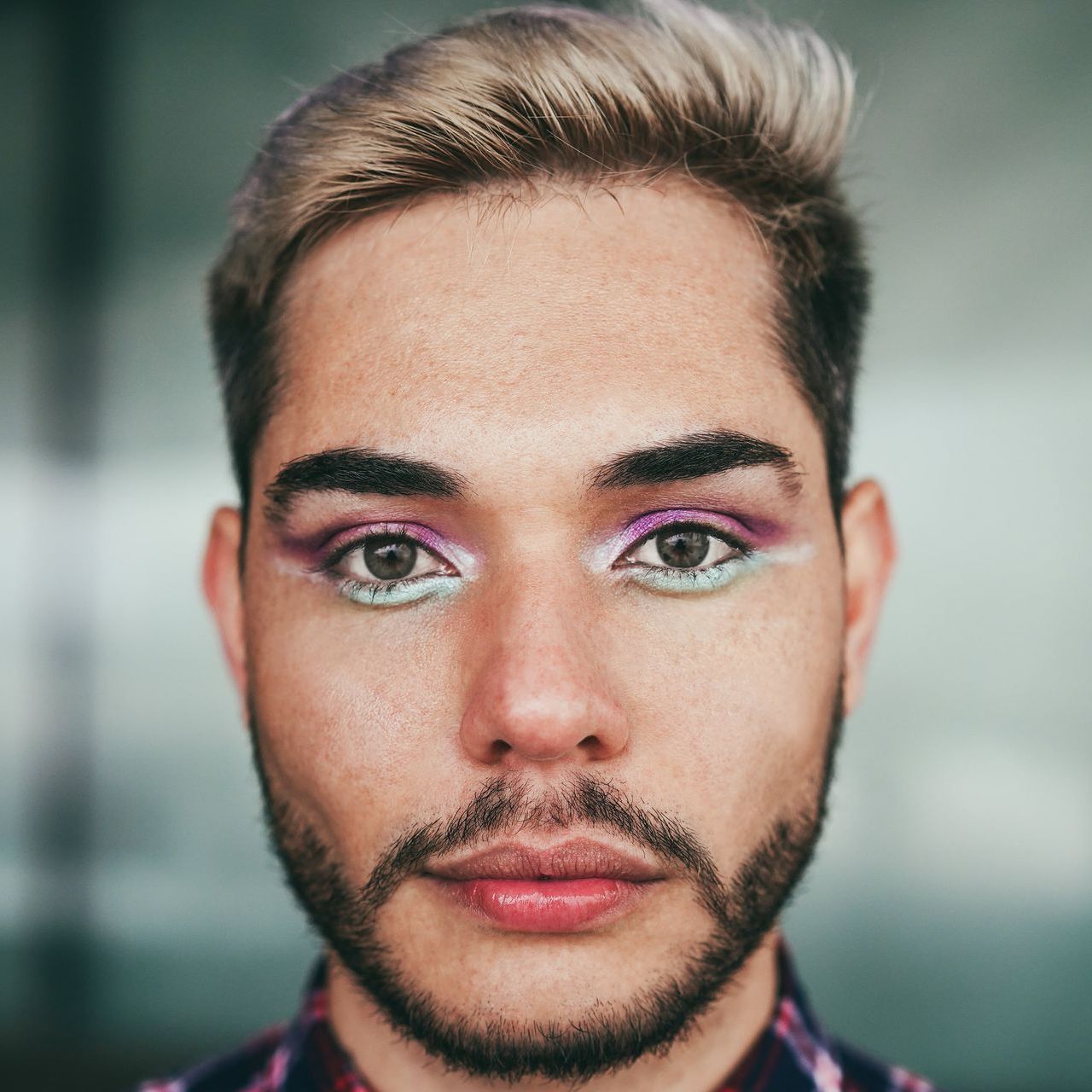 A close up of a person's face with purple eye makeup.
