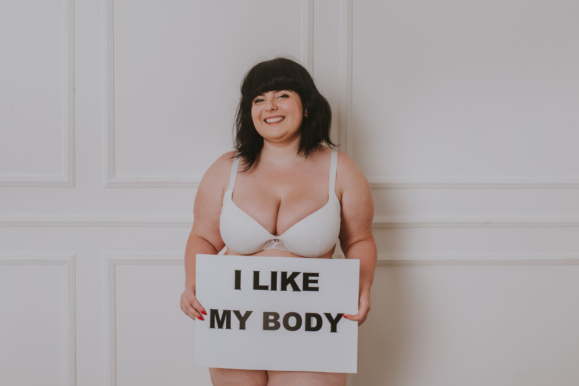 A young person with pink hair is wearing a fur coat and sunglasses.