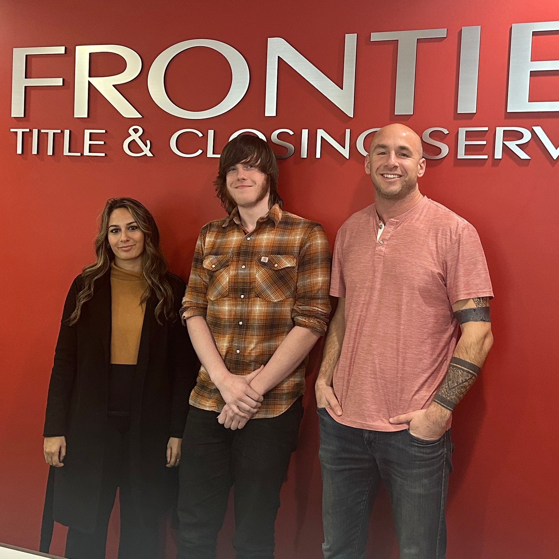 Three people posing in front of a 