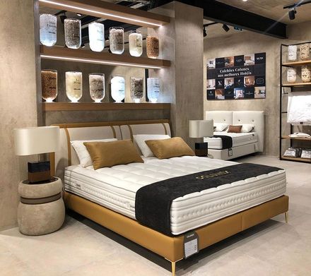 A bedroom with a bed , nightstands , lamps and shelves.