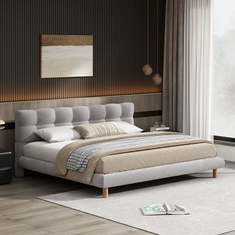 A bed is sitting in a bedroom next to a window.