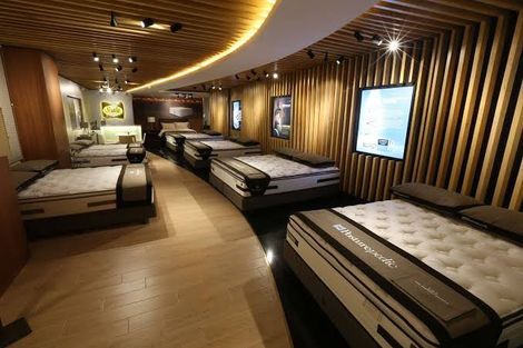 A room filled with mattresses in a store.