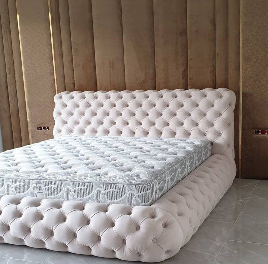 A bed with a tufted headboard and mattress in a bedroom