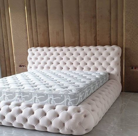 A bed with a tufted headboard and mattress in a bedroom