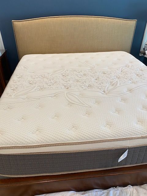 A bed with a mattress and a headboard in a bedroom.