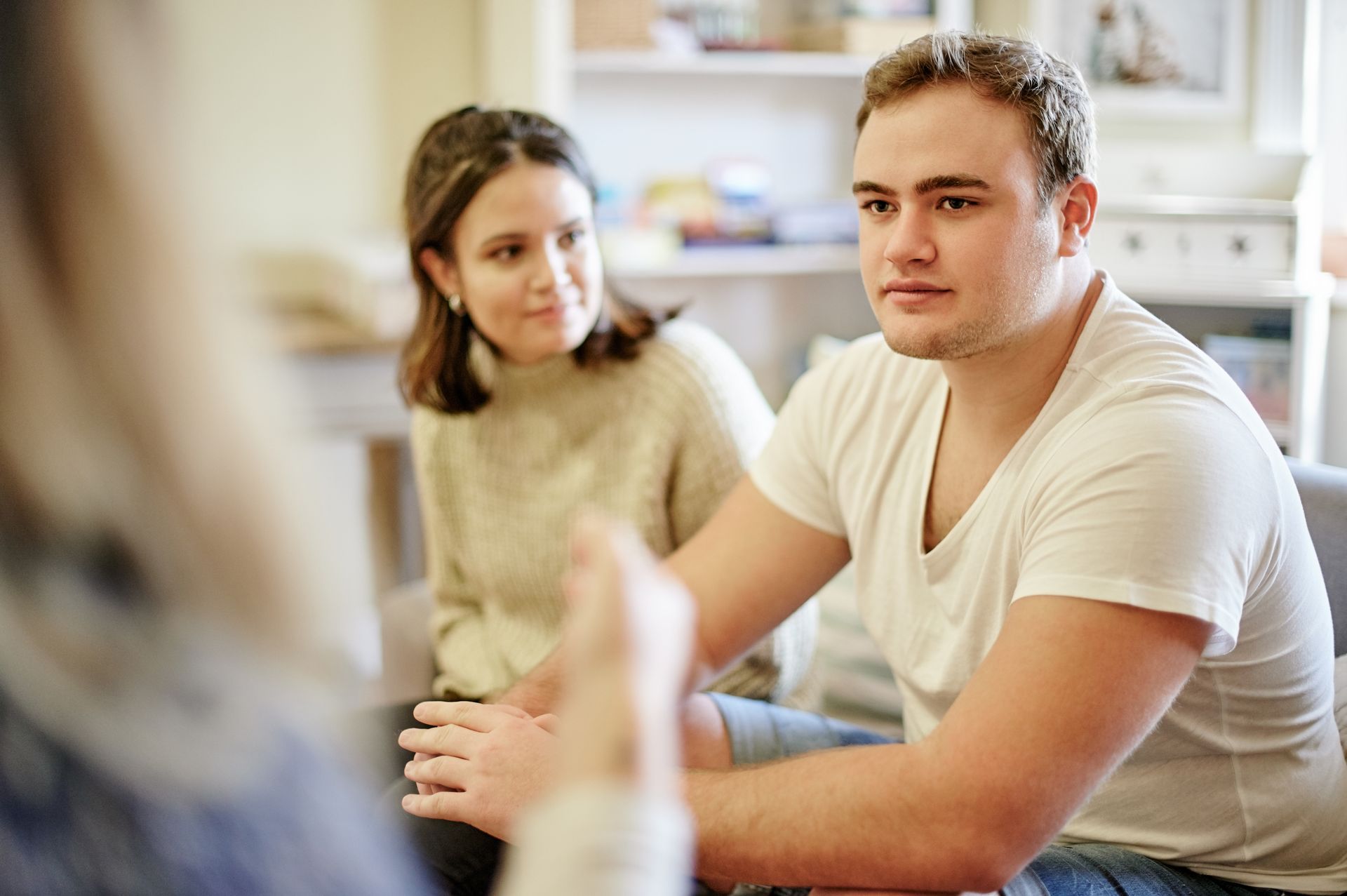 A man and a woman are sitting at a table talking to each other.