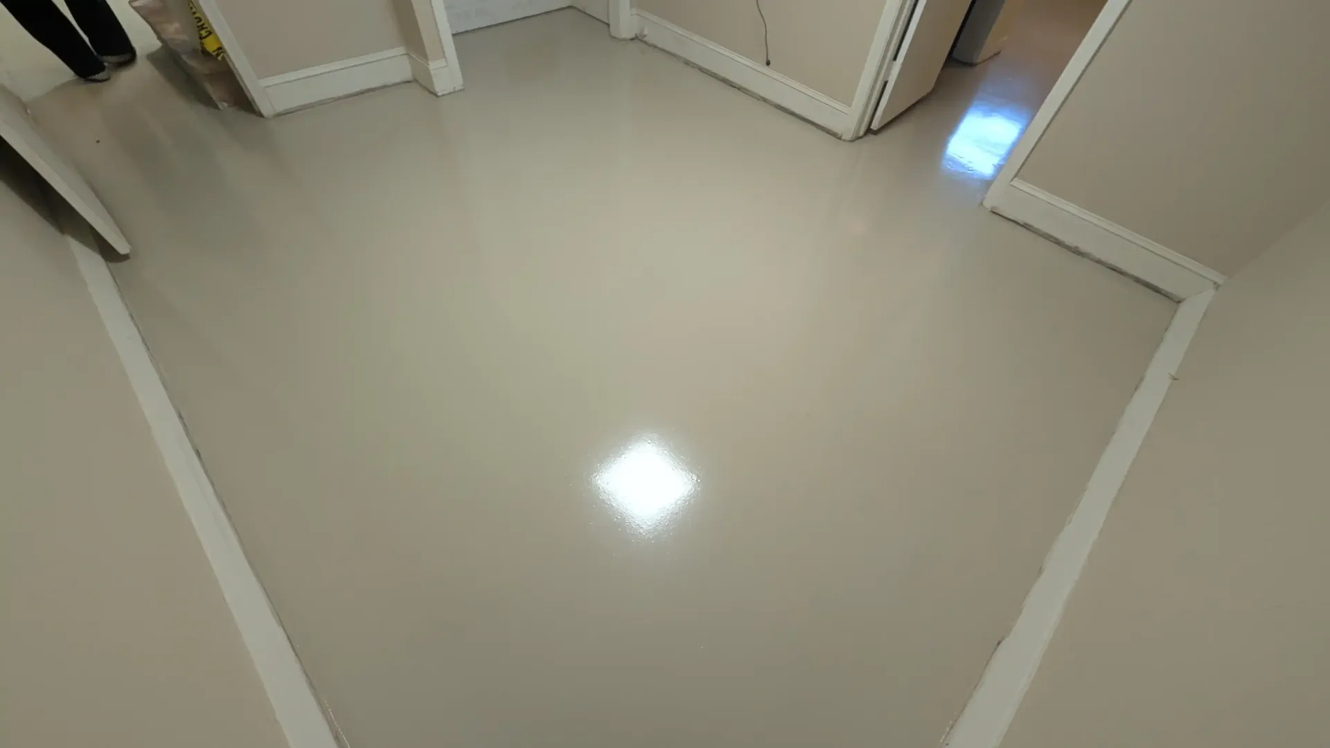 A large room with a concrete floor and a white wall.