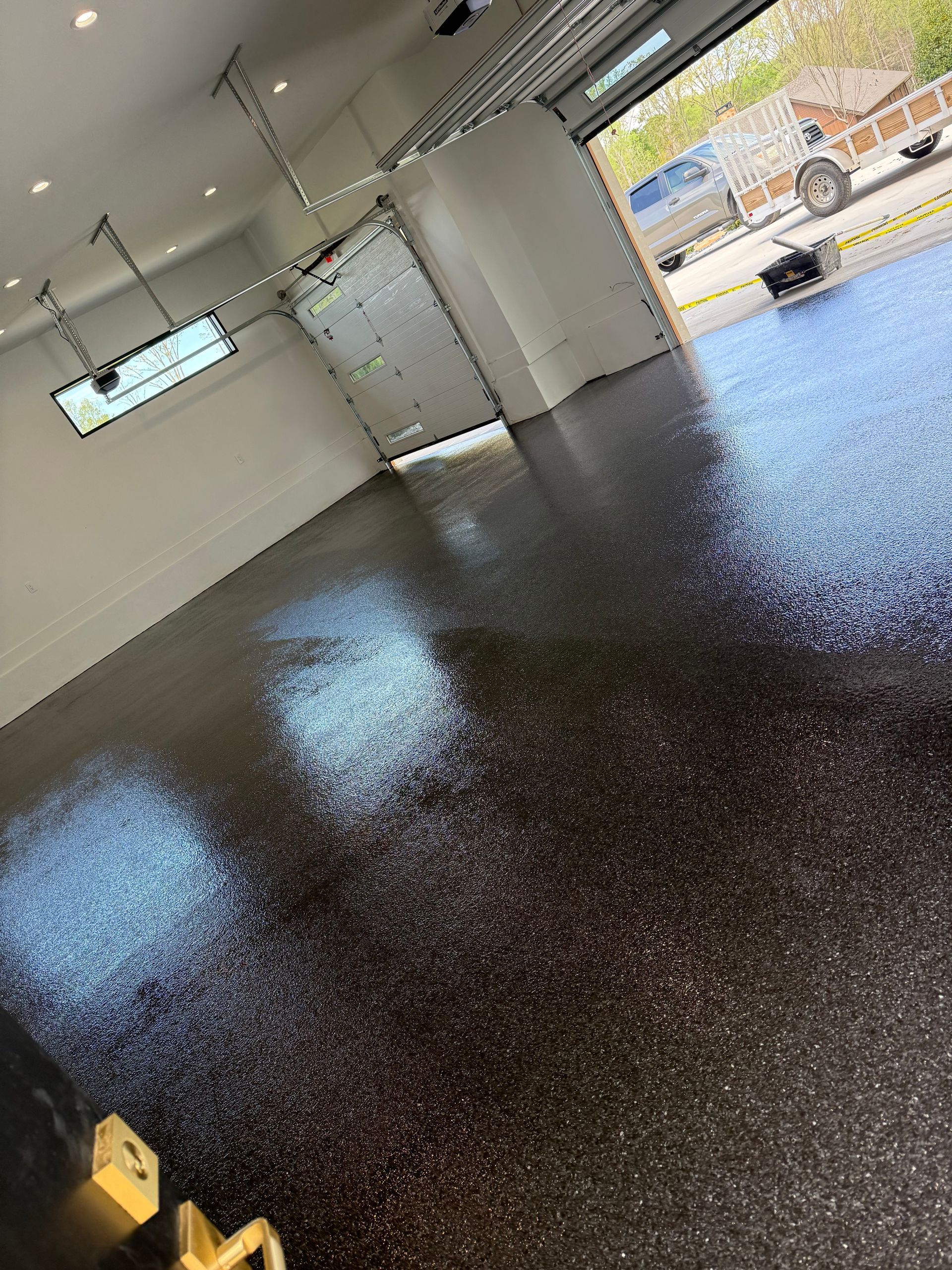 Black epoxy flake garage floor with glossy finish installed by Zachary Daniel Concrete in Belton, SC.