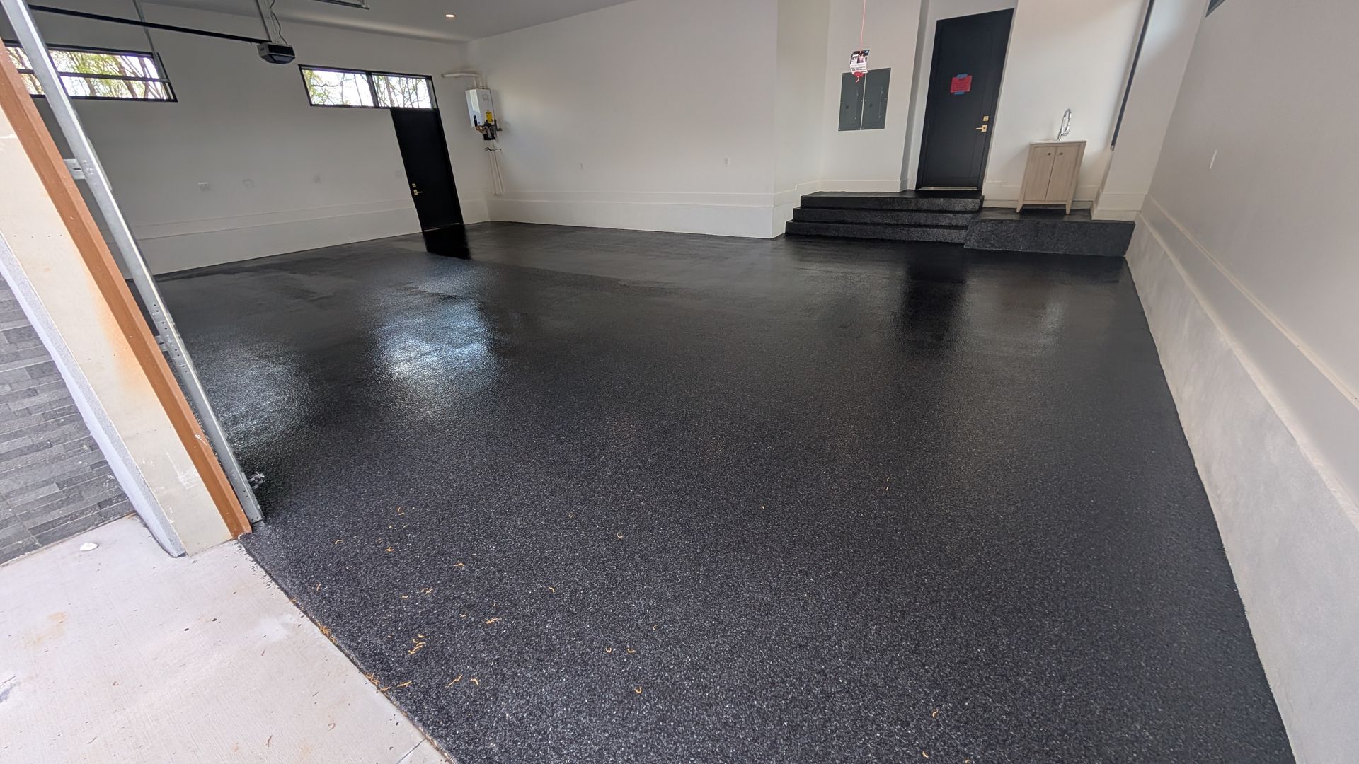 Black flake epoxy garage floor with light contrast installed by Zachary Daniel Concrete in Joanna, SC.