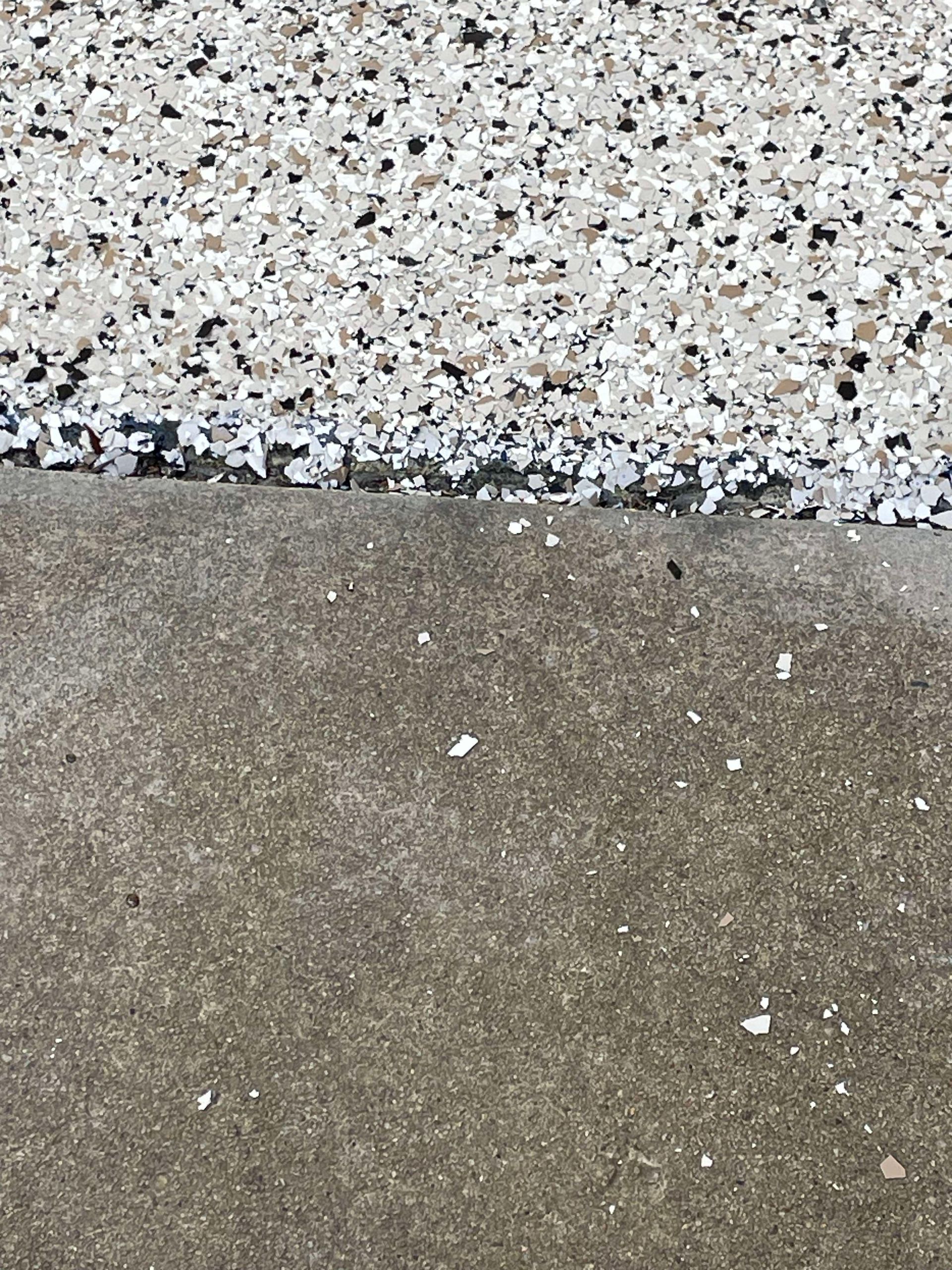 White and gray epoxy flakes on driveway surface installed by Zachary Daniel Concrete in Spindale, NC.