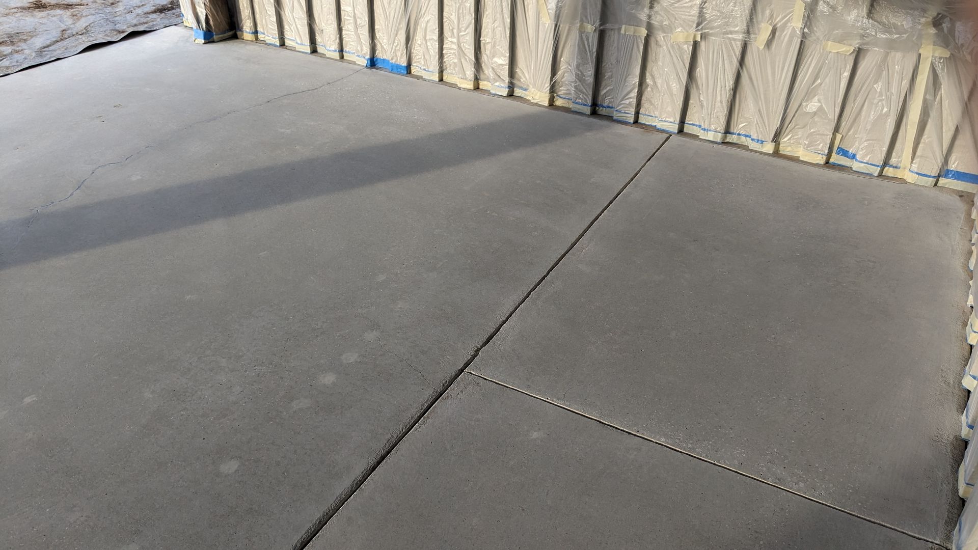 A close up of a concrete floor with a brick wall in the background.