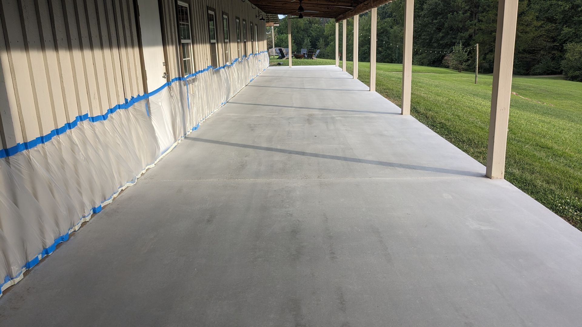 A long concrete porch with a blue tape on the side of it.