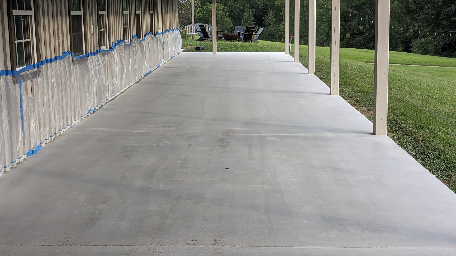 A concrete walkway leading to a house under construction.