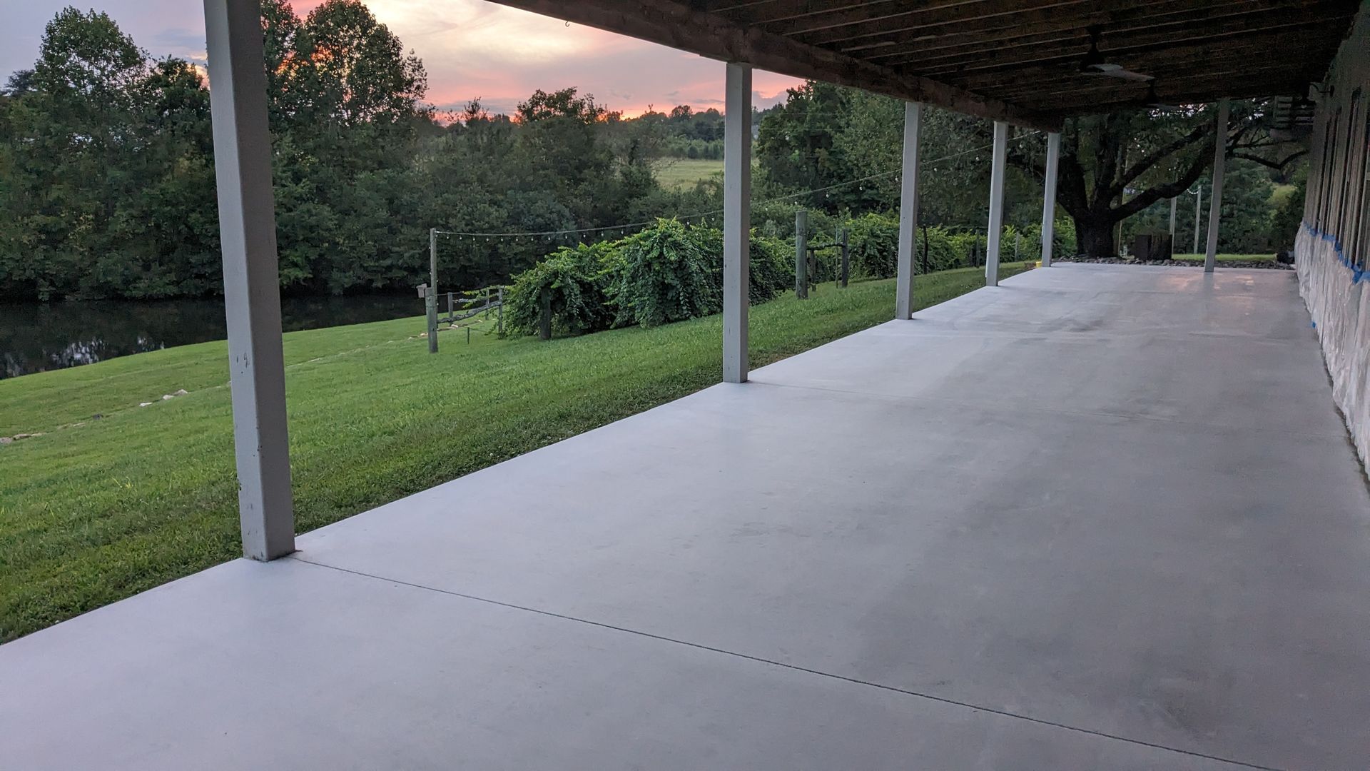 A large concrete porch with a view of a river.