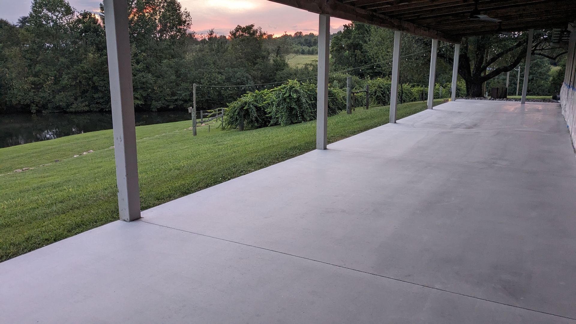A large concrete porch with a view of a river.
