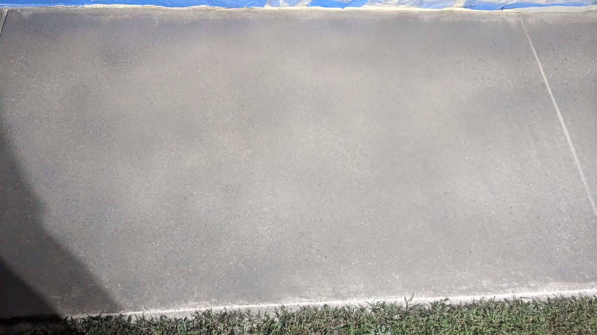 A close up of a concrete wall with grass in the background.