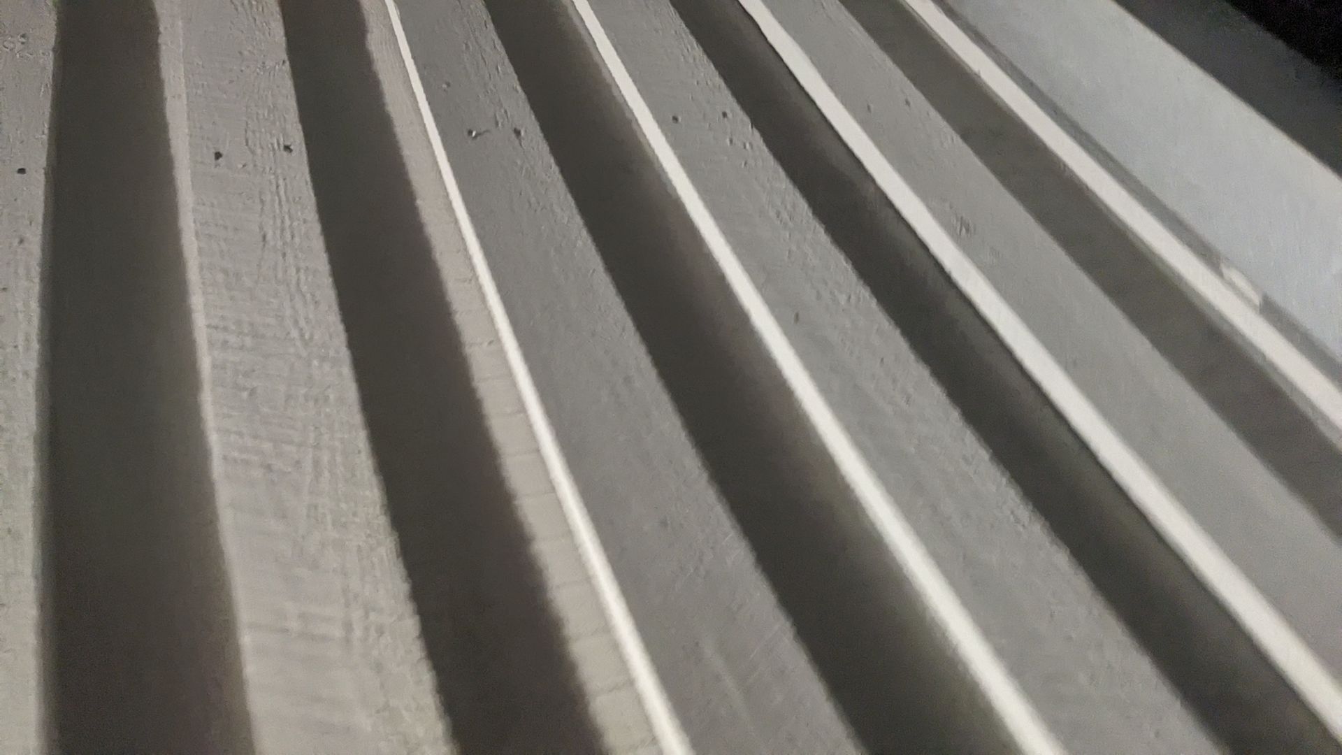 A close up of a metal roof with a shadow on it.