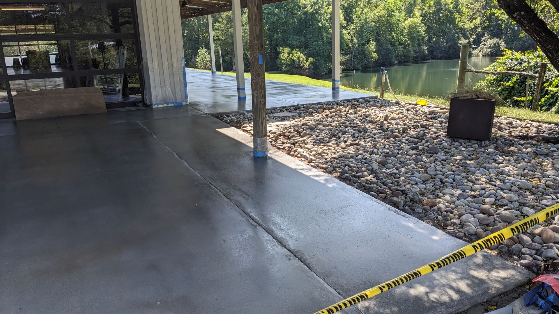 a concrete walkway leading to a house with a river in the background .