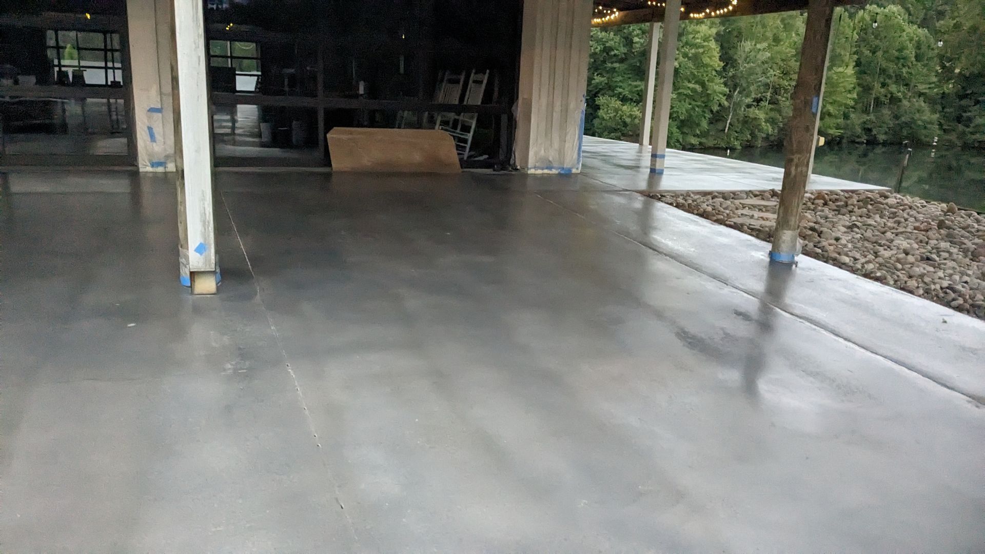 a concrete floor with a wooden structure in the background .